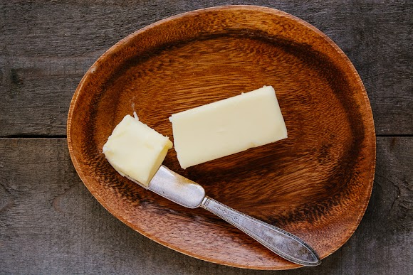 Stick of butter on a wooden plate with knife butter.jpg