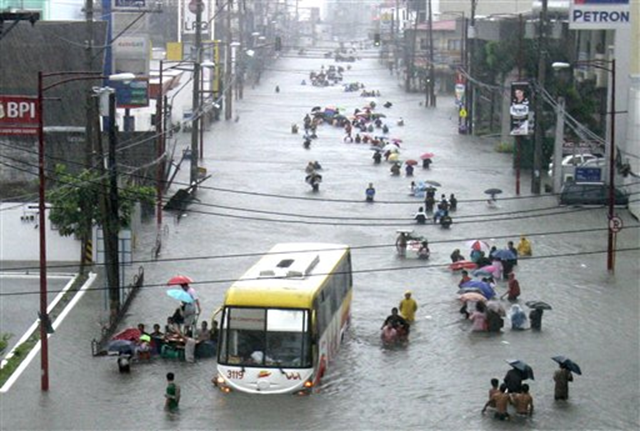 Commuters wade through waist-deep floodwaters following heavy rains brought about by tropical storm Ketsana (locally known as Ondoy) Saturday, 26 September 2009 in Manila, Philippines. At least five people have been killed after nearly a month&rsquo;s worth of rain fell in just six hours Saturday, triggering the worst flooding in the Philippine capital in 42 years, stranding thousands on rooftops in the city and elsewhere as Tropical Storm Ketsana slammed ashore. Bullit Marquez / AP Photo
