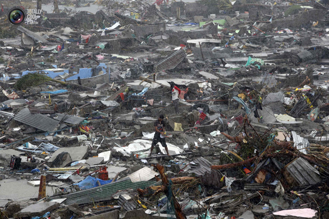 A man stands atop debris as residents salvage belongings from the ruins of their houses after Typhoon Haiyan battered Tacloban city in central Philippines. Photo: ERIK DE CASTRO / REUTERS