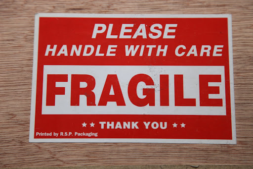 The sign says 'FRAGILE' so we better be careful.