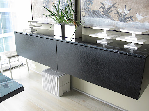 One long slab of marble sits on top of both credenzas, one in the dining room and one in the living room area, to protect the surface and add some glamour.