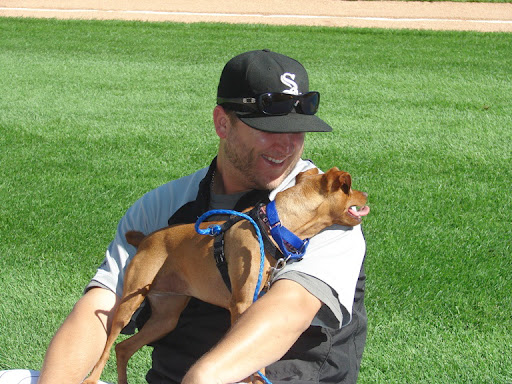 A lucky adoptable pooch cuddles with Mark on the field before a game. A lucky adoptable pooch cuddles with Mark on the field before a game.