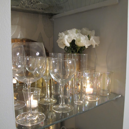 Sprinkling votive candles among the glassware really makes them shine.