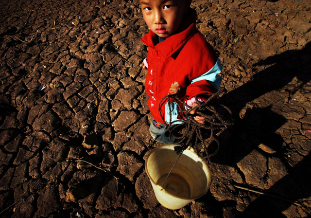 Southwest China is in the throes of a persistent drought. Above, a young boy stands in the middle of a dried-out reservoir in Guiyang, Guizhou province, on 2 February 2010. stringer / AFP / Getty Images