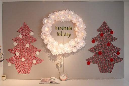 The shop was all decked out for the holidays. Rachel, the store owner, made one of our wreaths from the book, which you can get the instructions for here: http://www.marthastewart.com/how-to/paper-doily-wreath
The team also used Liberty fabric to create these trees and we cut ornaments out of red and white felt to decorate them.