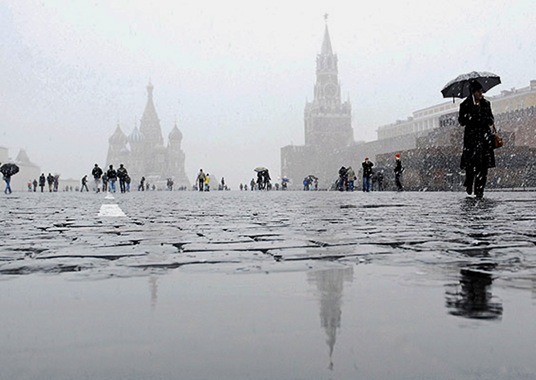 People walk across Red Square during first snow in Moscow October 14, 2007. Seen in the background are St Basil's Cathedral and the Kremlin.  REUTERS/Yushko Oksana  (RUSSIA) RUSSIA/