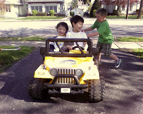 Kai and Eidan riding on the neighbor's battery powered mini Jeep