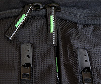 The metal zippers are hidden behind rubber caps so that they don't flap around. The other zippers have reflective thread running through them for better visibility