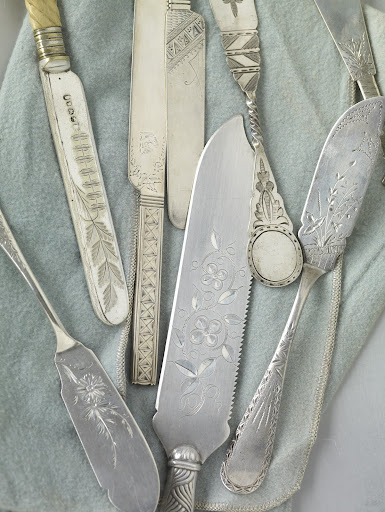 These butter and dessert knives, along with a large ice cream knife, center, represent a variety of styles, including delicate Japanese-inspired motifs, geometrics, and patterns that mix flowers, leaves and vines. These butter and dessert knives, along with a large ice cream knife, center, represent a variety of styles, including delicate Japanese-inspired motifs, geometrics, and patterns that mix flowers, leaves and vines.