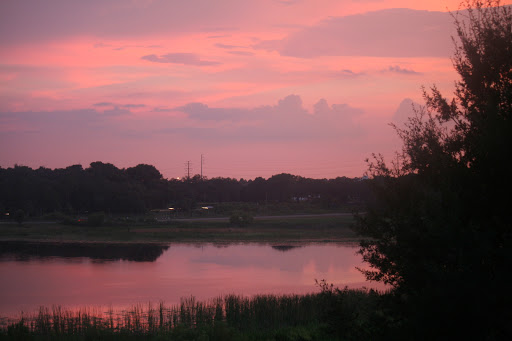Sunset with crescent moon over lake at Plantation Lakes Apartments