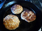 Salmon burgers ready to be removed from the pan.