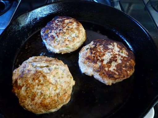 Salmon burgers ready to be removed from the pan.