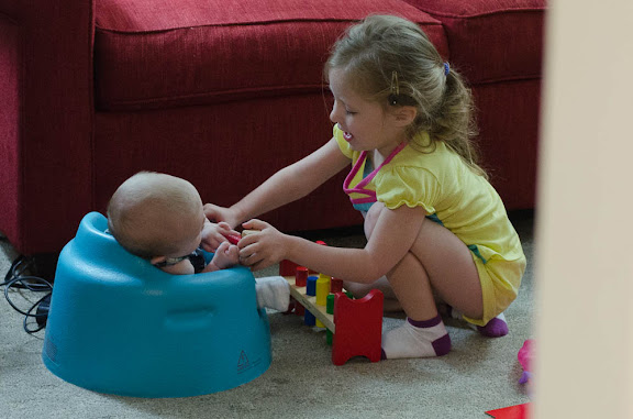 Sam trying to get Nate to play with her toys