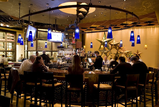 The bar at Table 10. The blue pendant lamps set the bar apart from the warm tones in the dining area. The bar at Table 10. The blue pendant lamps set the bar apart from the warm tones in the dining area.