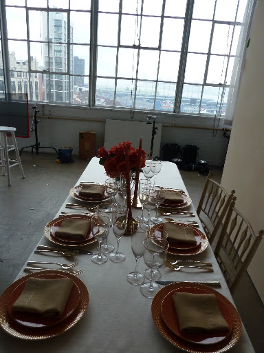 The red table in the beginning stages of being set.