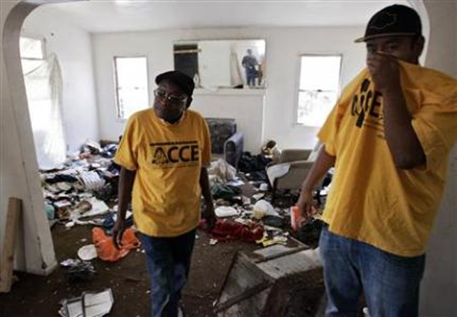 Activists stand in a living room of a foreclosed home, where squatters have been living, during a blight tour that the activists say highlight how big banks are hurting local communities by failing to maintain their foreclosed properties, in Los Angeles, California, in this 17 May 2012 file photo. REUTERS / Jonathan Alcorn
