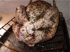Inside, we place the turkey on the cooking rack, then cover it with the salt-and-pepper rub and stuff the cavity. A sheet pan beneath it keeps the counter clean. Inside, we place the turkey on the cooking rack, then cover it with the salt-and-pepper rub and stuff the cavity. A sheet pan beneath it keeps the counter clean.