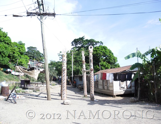 Dubu - four totem poles stand in contrast to the power pole