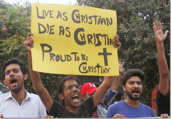 A member of the Pakistani Christian community holds a placard as he shouts slogans during a protest rally to condemn Sunday's suicide attack in Peshawar on a church, with others in Lahore September 23, 2013