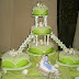 Nº139: Terminación de carpeta de encaje sobre una base de fondant extendido verde pistacho. Rosas blancas de azúcar. Montaje sobre pilares y con escaleras para las tortas satélite.