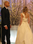 An Amsale gown featuring bow detail. The groom is wearing a black suit both from Kleinfeld. An Amsale gown featuring bow detail. The groom is wearing a black suit both from Kleinfeld.