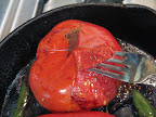 When the skin starts to come loose, you can start lifting it off with a fork. Keep cooking and turning the tomatoes as you go.