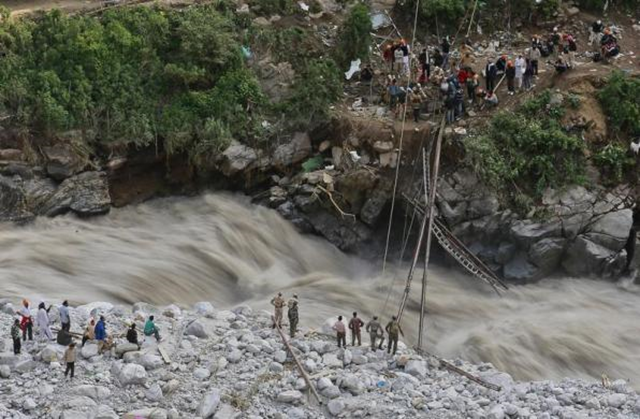 Soldiers try to repair a temporary footbridge over River Alaknanda after it was destroyed, during rescue operations in Govindghat in the Himalayan state of Uttarakhand, 22 June 2013. Early monsoon rains have swollen the Ganges, India's longest river, swept away houses, killed at least 138 people and left tens of thousands stranded, local newspapers reported. Photo: Danish Siddiqui / REUTERS