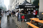 An afternoon rainshower wasn't enough to keep thousands of New Yorkers from chowing down at the BBQ Party, but it did inspire some huddled masses to form under every available tent.