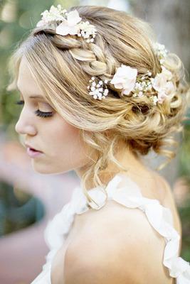 The delicate white flowers are the perfect accessory to this braided updo