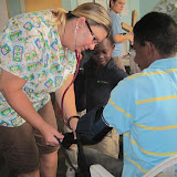 Denise checking a blood pressure with Ricardo watching