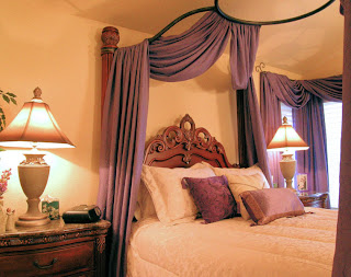 Beautiful lamps with hand-painted shades cast soft lighting in this romantic bedroom.