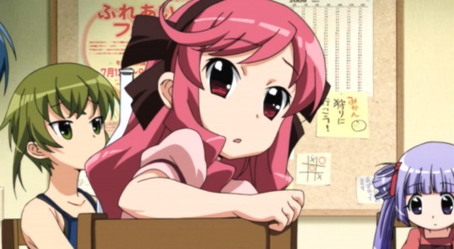 Mika with colorful pink hair replete with bows twists to look over the back of her chair at the viewer as a few others in the background pay little attention