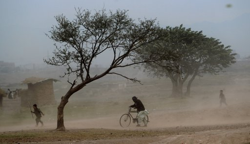 A Pakistani man pushes his bicycle while children run away as they get caught in a sandstorm on the outskirts of Islamabad, Pakistan, Tuesday, 8 November 2011. Muhammed Muheisen / AP Photo