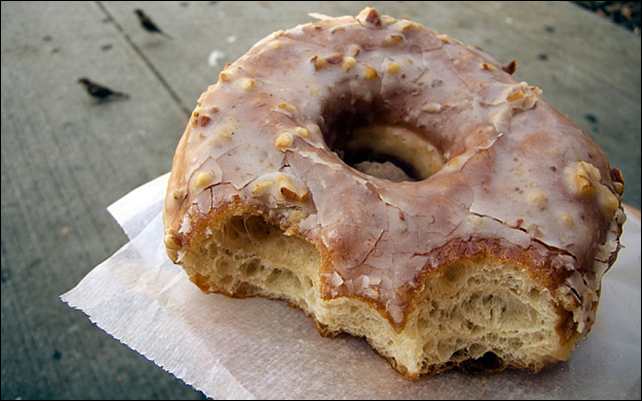 A half-eaten glazed doughnut. 1,000 calories made up from healthy items cost an average of &pound;7.49 in 2012 while the same calorie intake from less healthy items, including doughnuts, could be purchased for an average of &pound;2.50. Photo: Alamy