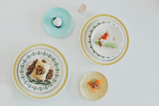 Use garnishes and plates to bring in color. Here, a Pop-Tart bite with vanilla bean Cool Whip and a shot of Ovaltine, a Buffalo wing duo, pulled pork on classic Doritos, and short rib beef Wellington with mushroom duxelle.