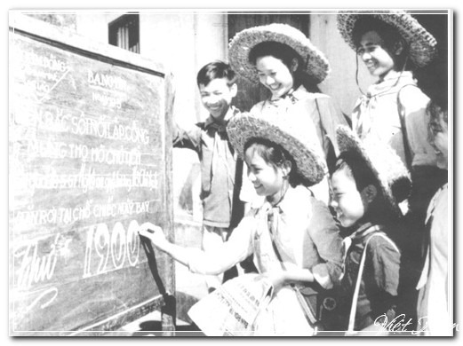 Các bạn học sinh viết phấn lên bảng chào đón ngày tựu trường trong những năm kháng chiến ở miền Bắc.