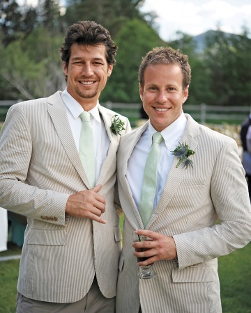 A pair of groomsmen mug for the camera in suave striped suits. Groom Peter gave them all custom Nike sneakers that sported the wedding date and each man's last name. A pair of groomsmen mug for the camera in suave striped suits. Groom Peter gave them all custom Nike sneakers that sported the wedding date and each man's last name.