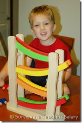 boy in front of colorful wooden toy