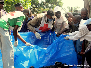 Des volontaires, des policiers et les membres de la Croix Rouge National, tentent de dégager les corps calcinés ce 20/05/2011 à Kinshasa, lors d'un incendie qui avait tué six membres d'une même famille. Radio Okapi/ Ph. John Bompengo