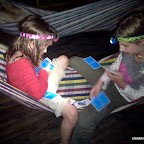 The girls play cards in the hammock at night. The girls play cards in the hammock at night.