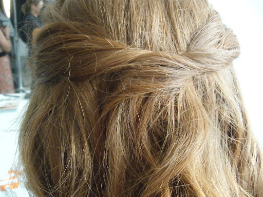 After twisting back two strands and securing them with a bobby pin, Sadah covered the pin by sweeping a lock over it. She pinned that hair in place from underneath.