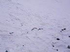 Saturday Morning from the top of the ridge. Our tent behind the snow wall we dug out of the little ridge of snow. Note our packs tethered to keep them from sliding into the crevasses below. Note the rocks fallen from the cliffs above. Not last night, thankfully.