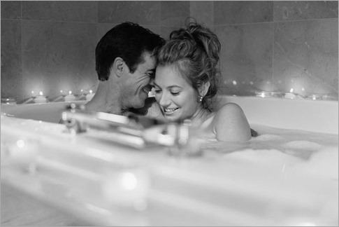 Man and young woman soaking in bath, smiling-1707661