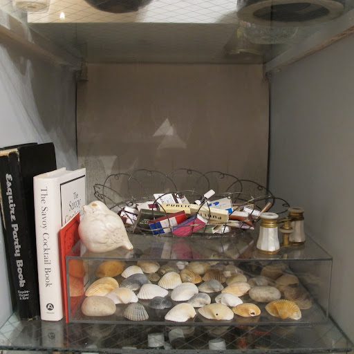 I shopped my own house to fill the bottom shelf that used to be stuffed with cookbooks. The Lucite box holds shells I've collected all my life. The mother-of-pearl opera glasses were my grandmother's.