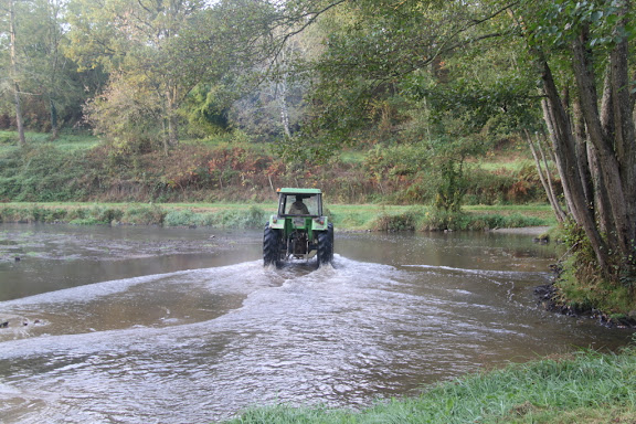 De trekker rijdt door het water bij ons kampeerplekje