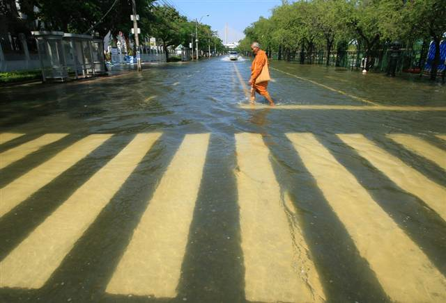 A Thai Buddhist monk wades through floodwater on a streat near Sanam Luang square near Chao Phraya River in Bangkok, Thailand, 1 November 2011. Narong Sangnak  /  EPA