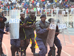 Les éléments de la police nationale Congolaise entourent les arbitres en courant, ce 20 mars 2011 au stade des matyrs à Kinshasa, lors du match V Club de Kinshasa et Coton sport de Garuwa du Cameroun. Radio Okapi / Photo John Bompengo