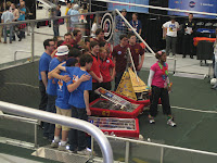 Pit crew poses with robot for photo