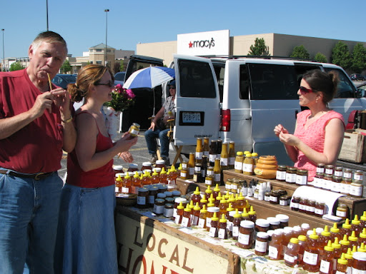 A Springfield local samples local honey, while a Farmers' Market vendor explains how the nectar is made.