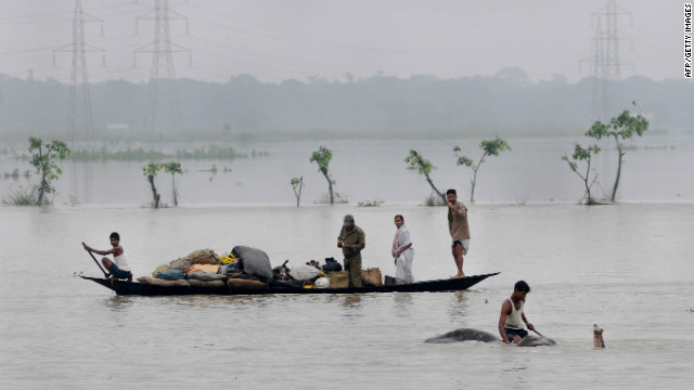 Villagers padddle with their belongings through flood waters in the Pobitora Wildlife Sanctuary, 55 kms from the capital city of the northeastern state of Assam on 28 June 2012. Floodwaters have submerged 90 percent of the sanctuary. AFP / Getty Images